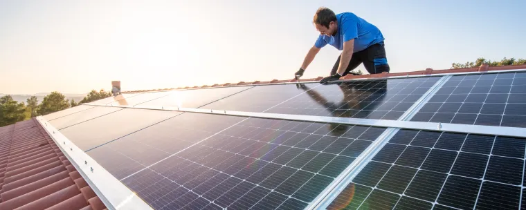 hombre instalando paneles solares en una casa