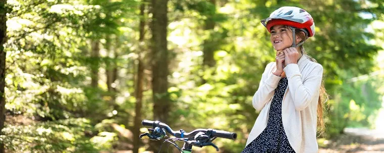 niña andando en bici en un bosque