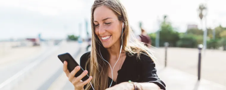 mujer usando celular y auriculares